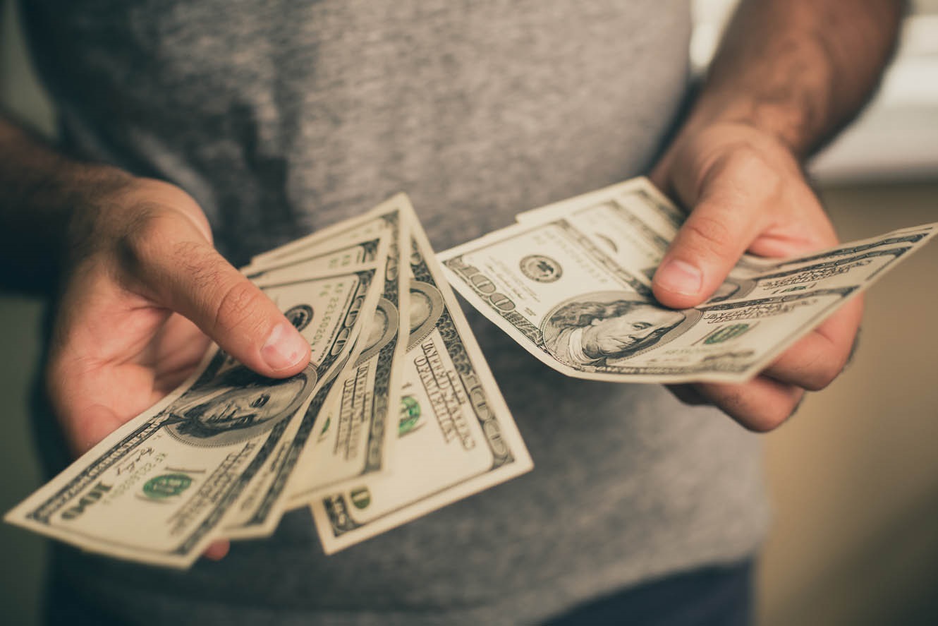 Person counting dollar bills